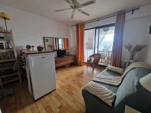 - un salon avec un canapé et un réfrigérateur dans l'établissement Appartement Port Grimaud, à Grimaud