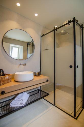 a bathroom with a sink and a mirror at Alma Sunset Suites in Ios Chora
