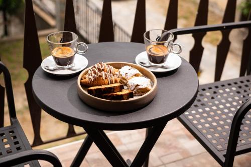 a table with a bowl of bread and two glasses of tea at Tsikeli Boutique Hotel Meteora - Adults Friendly in Kalabaka