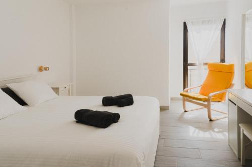 een hotelkamer met een bed en een stoel bij Happy House - Downtown Apartment in Corralejo