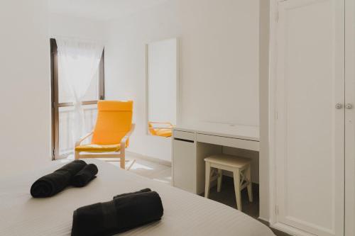 een kantoor met een oranje stoel en een tafel bij Happy House - Downtown Apartment in Corralejo