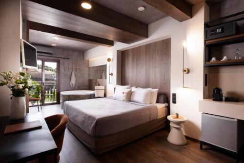 a hotel room with a bed and a desk and a table at Tsikeli Boutique Hotel Meteora - Adults Friendly in Kalabaka