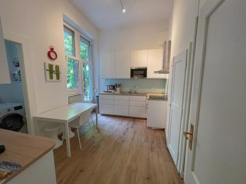 une cuisine avec des armoires blanches et une table à l'intérieur dans l'établissement Appartement de standing 200m², à Strasbourg