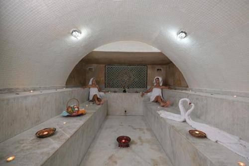 Dos personas sentadas en una bañera con cisnes en Valeria Jardins d'Agadir - All In, en Agadir