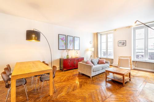 un salon avec une table et un canapé dans l'établissement Apt élégant près des Galeries Lafayette, à Paris