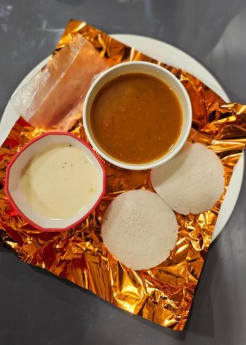 苏拉特Hotel SERENE STAY的一大盘食物,配上一碗汤和饼干