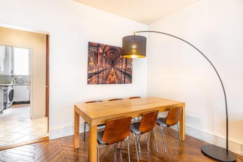 une salle à manger avec une table et des chaises en bois dans l'établissement Apt élégant près des Galeries Lafayette, à Paris