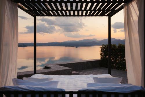 a room with a bed and a view of the water at Cape of Senses in Torri del Benaco