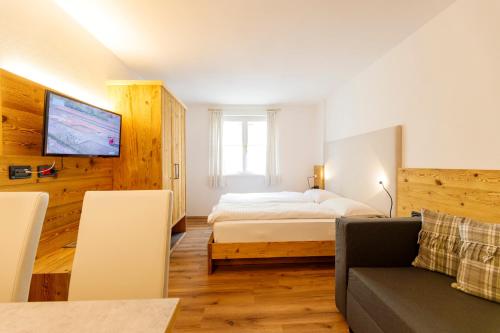 a bedroom with a bed and a couch at Residence Montebel in Tesero