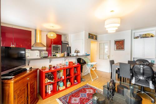une cuisine avec des placards rouges et une étagère rouge dans l'établissement GuestReady - Red Letters in Montrouge, à Montrouge