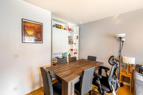 une salle à manger avec une table et des chaises en bois dans l'établissement GuestReady - Red Letters in Montrouge, à Montrouge