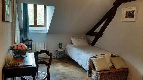 une petite chambre avec un lit et une table dans l'établissement Gîte Les Rimbaudières à Ligueil, à Ligueil