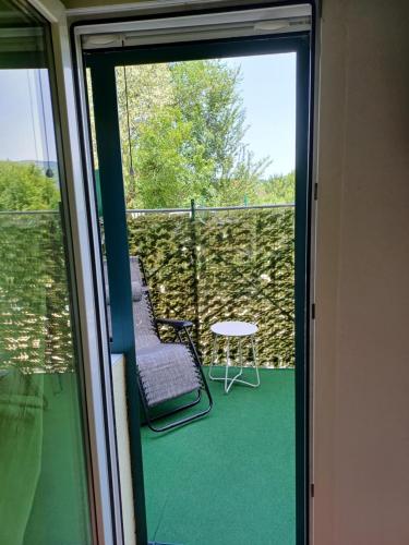 a balcony with a chair and a table and a window at Guest house Slatki Snovi in Knin
