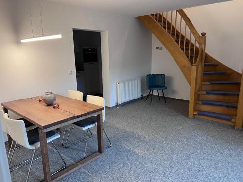 a dining room with a table and chairs and a staircase at Erlebniseck in Simmelsdorf