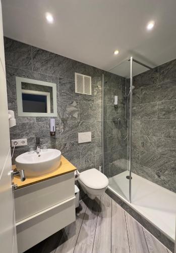 a bathroom with a sink and a toilet and a shower at Mertinkus Nordseehotel in Cuxhaven