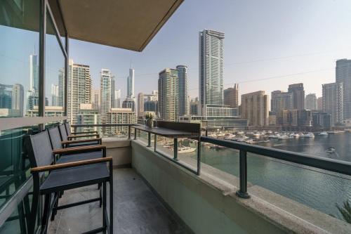 a balcony with two chairs and a view of the city at GuestReady - Bohemian Apt with Marina View in Dubai