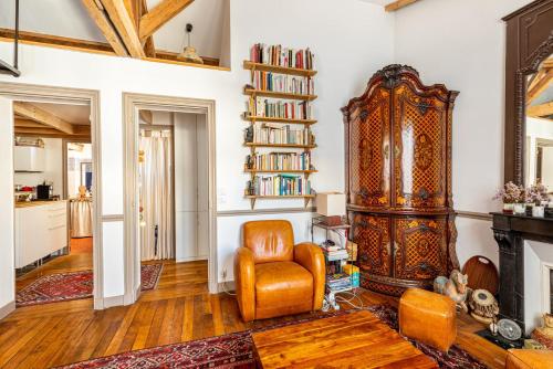 - un salon avec une chaise et une étagère dans l'établissement GuestReady - Charming apartment with mezzanine, à Paris
