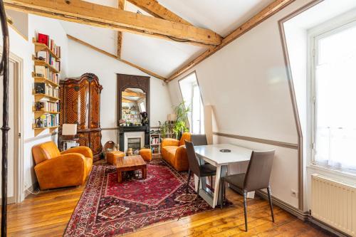 un salon avec une table et des chaises dans l'établissement GuestReady - Charming apartment with mezzanine, à Paris