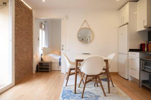 Una cocina y un comedor con mesa y sillas. en GuestReady - Acogedor Apt en La Barceloneta, en Barcelona