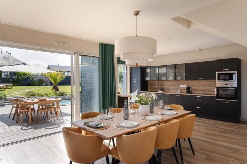 a kitchen and dining room with a table and chairs at Home by the Sea - Maison Cancale proche de la mer in Cancale