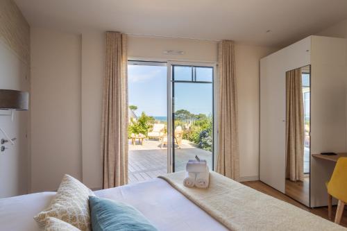 a bedroom with a bed with a view of the ocean at Home by the Sea - Maison Cancale proche de la mer in Cancale