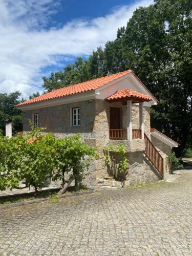 a small stone house with a red roof at Quinta da Cavada - Casa da Tertúlia in Vouzela