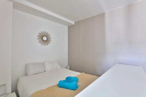 une petite pièce avec un lit avec un objet bleu dessus dans l'établissement Bel appart à 5 min à pied de la station de métro, à Paris
