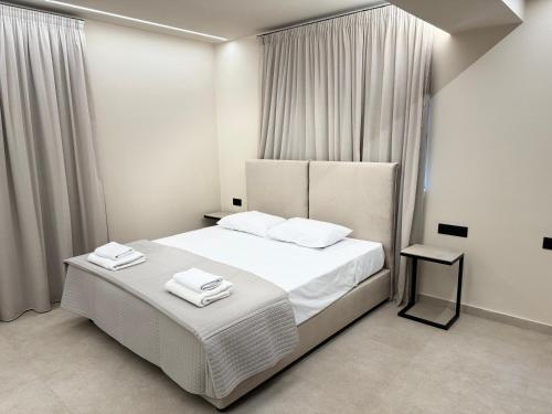 a bedroom with a white bed with towels on it at Home of the Muses in Ayia Napa