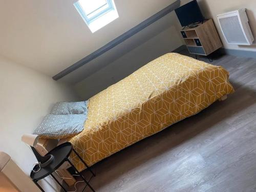 une petite chambre avec un lit et une chaise dans l'établissement Appartement charmant à Vichy, 28 m², parking inclus, à Vichy