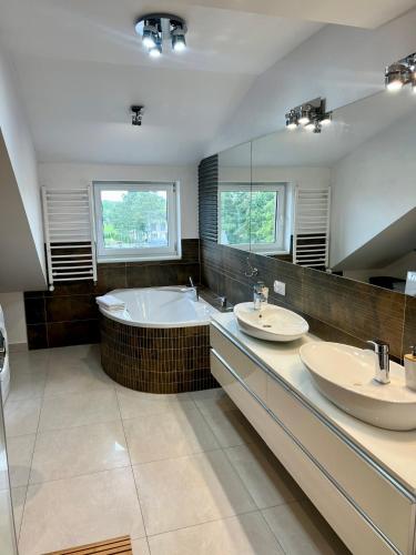 a bathroom with two sinks and a tub and a large mirror at Old Tree Villa & Restaurant in Oświęcim