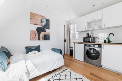 - une chambre avec un lit et un lave-linge dans l'établissement Studio refait a neuf dernier etage - Paris 19 - 2P - FLAT-GUEST - FLAT-GUEST, à Paris