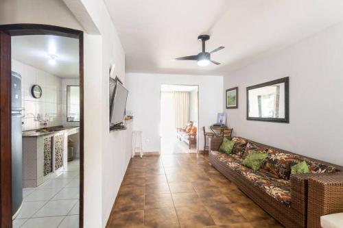 a living room with a couch and a kitchen at Casa Privativa com Piscina, Churrasqueira, Mesa de Sinuca in Iguaba Grande