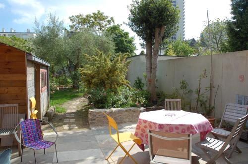 Un patio con mesa y sillas y una valla. en Chambre indépendante avec salle de bains privée, en Rennes
