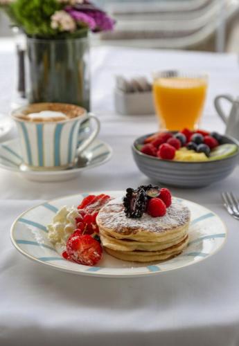 a plate with pancakes and fruit on a table at Casa Bianca Al Mare in Lido di Jesolo