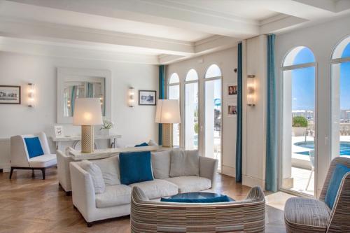 a living room with a couch and chairs and windows at Casa Bianca Al Mare in Lido di Jesolo