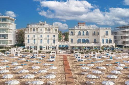 a group of chairs and umbrellas on a beach at Casa Bianca Al Mare in Lido di Jesolo