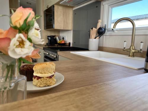 a sandwich on a plate on a counter in a kitchen at Swift Mosselle Pitch 24 Creek Caravan Park dog friendly in Ringstead
