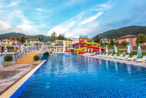 a pool at a resort with a water slide at Парк Хотел Модър in Devin