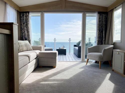 a living room with a view of the ocean at Swift Mosselle Pitch 24 Creek Caravan Park dog friendly in Ringstead