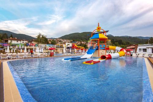 a pool at a resort with a water slide at Парк Хотел Модър in Devin