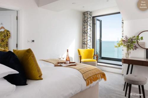 a bedroom with a bed with a view of the ocean at Luxury Coastal in St Ives