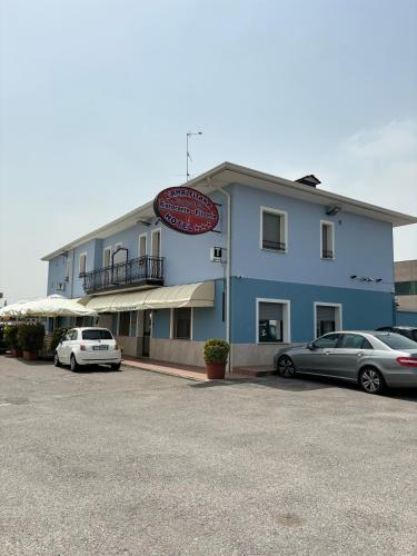 a blue building with cars parked in a parking lot at Hotel Ristorante Amalfitana in Dello