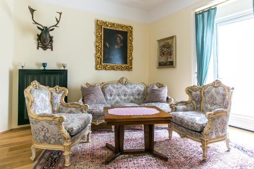 ein Wohnzimmer mit 2 Stühlen und einem Tisch in der Unterkunft Villa Thalhof in Bad Gleichenberg