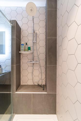 une douche dans une salle de bain avec une porte vitrée dans l'établissement Loft - Clim - Park - 5mn from the heart of town, à Pau