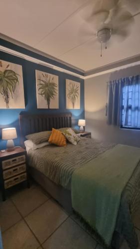 a bedroom with a large bed with blue walls at Aloe Cottage - Ramsgate Ramble Rest in Margate