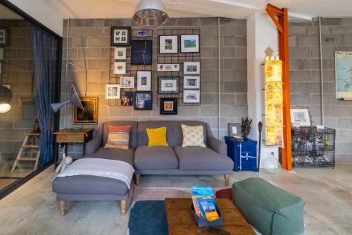 un salon avec un canapé avec des oreillers dans l'établissement Loft - Clim - Park - 5mn from the heart of town, à Pau