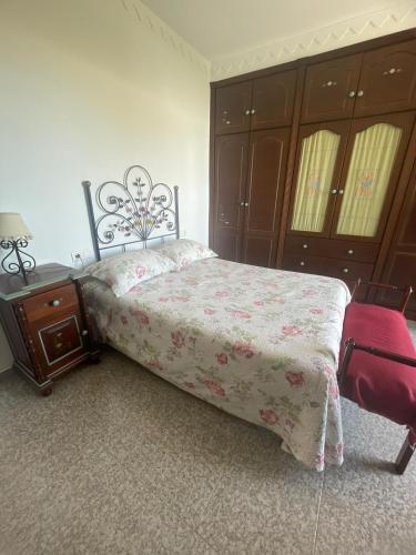 a bedroom with a bed and a table and a chair at Villa Familia in Écija
