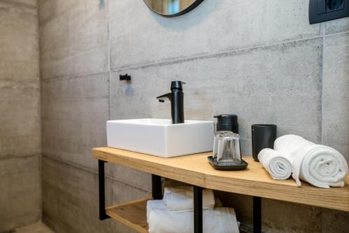 a bathroom with a sink and towels on a table at Apartma Stara Maslina in Rab