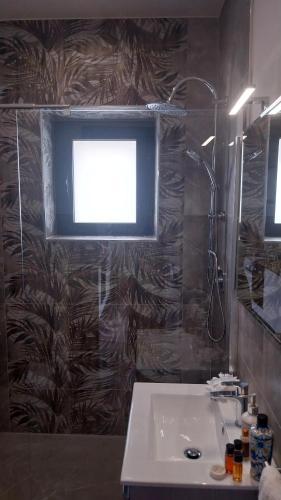 a bathroom with a sink and a window and a shower at Il Calice dell'Etna in Passopisciaro