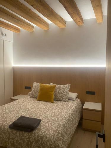 a bedroom with a bed with a yellow pillow at Apartamento Chapitela Deluxe in Pamplona